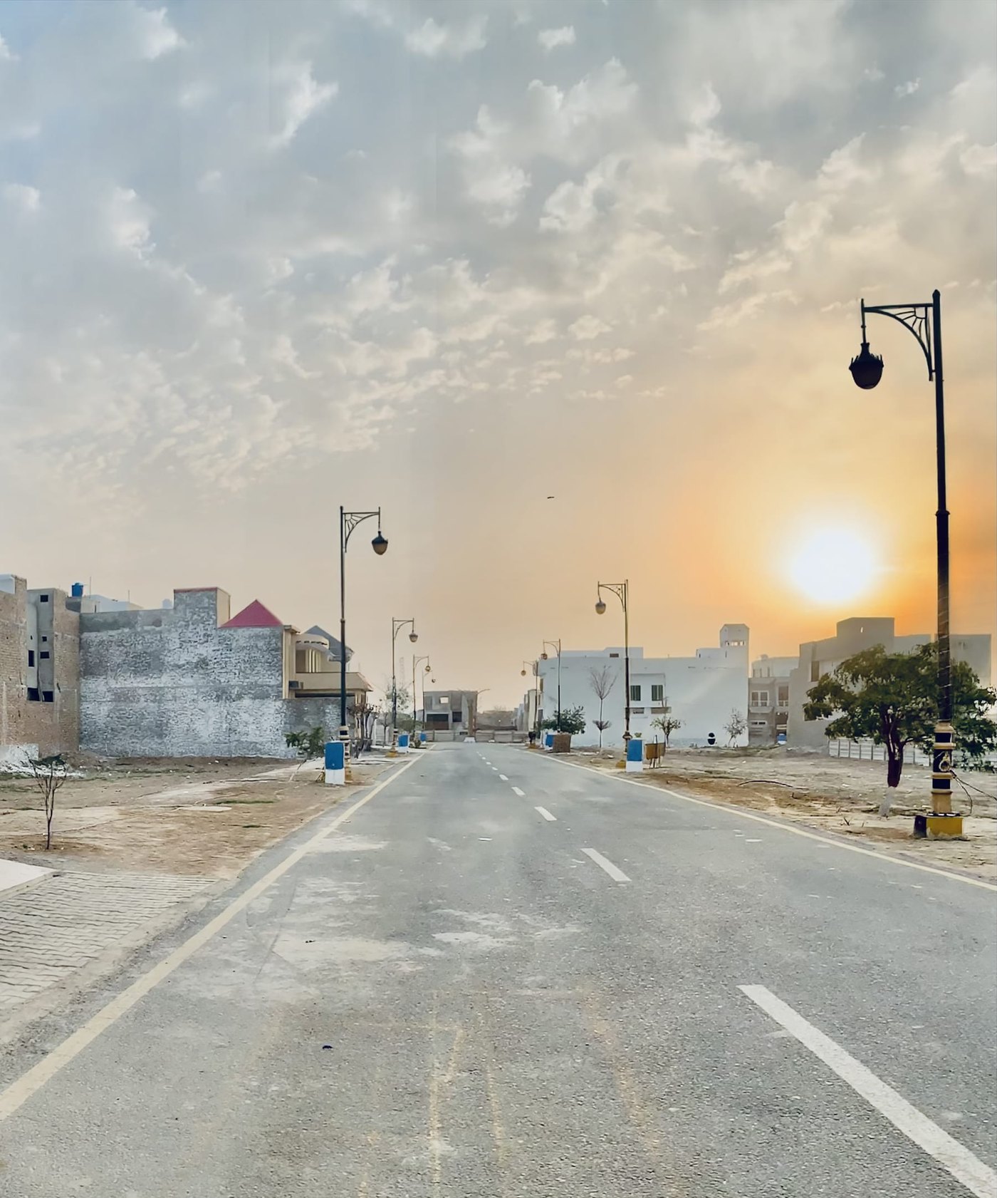 Landscaped boulevard with street lighting at golden hour in Japan Citi Bahawalpur
